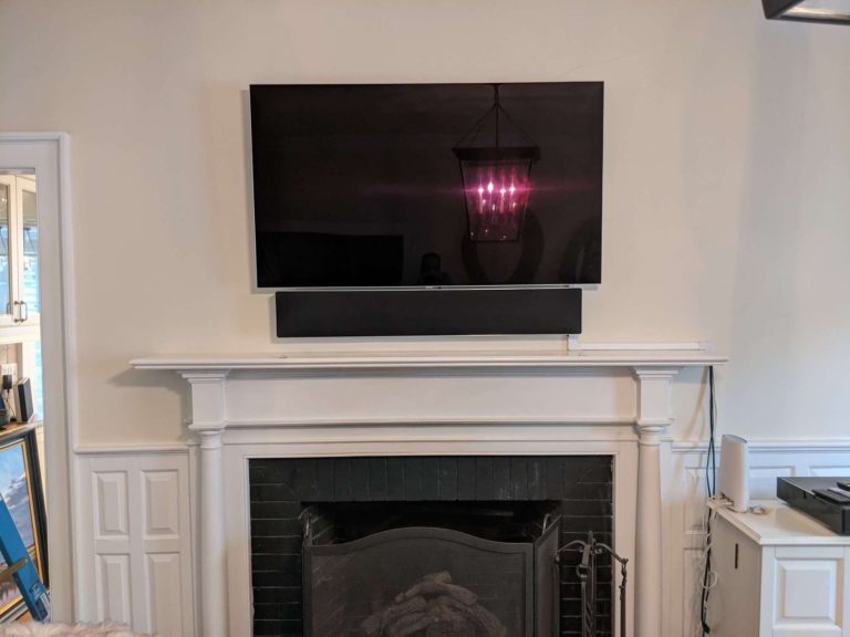 TV mounted above a fireplace with cords masked.