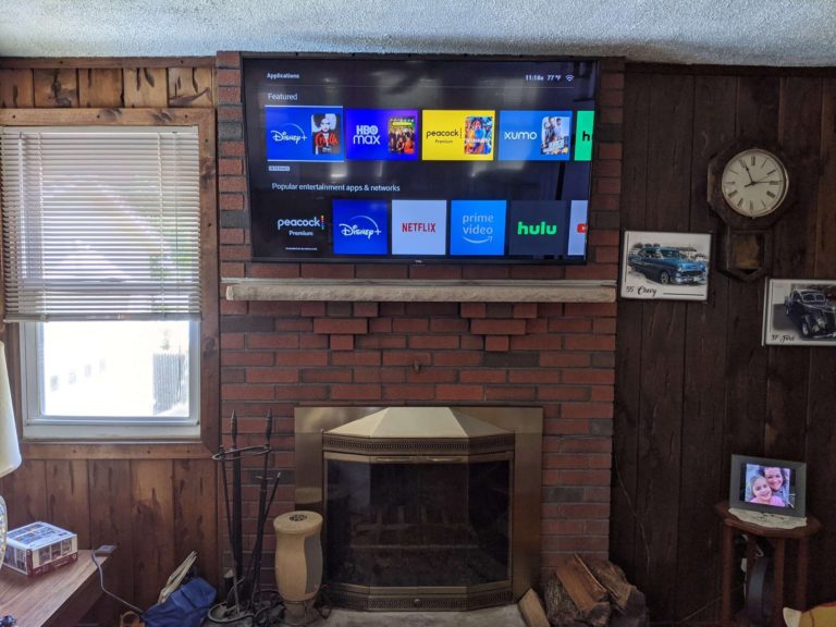 TV mounted above a brick fireplace.